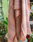Silica Rose In Shades of Salmon Pink Gray Stripes Pattern Soft Handwoven Merino Throw hanging in a floral decor setting.