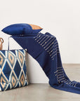Rosewood Indigo Hand Knotted Stripes Handloom Merino Throw displayed with decorative pillows and pottery.