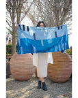 Harbor Blue Silk Merino Hand Woven Hand Embroidered Modern Artisanal Scarf displayed outdoors by a model.