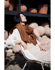 Coco Brown Hand Woven Linen Silk Blend Scarf styled with a casual outfit in a serene outdoor setting.