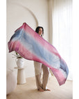 Woman holding the Iris Haze Blue Pink Cashmere Merino Handloom Scarf in soft sky blue and pink hues.