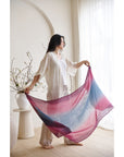 Model showcasing the Iris Haze Blue Pink Cashmere Merino Handloom Scarf indoors with natural light.