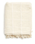 Sea Shell White Textured Checks Handloom Throw folded with checked pattern and fringes, handwoven cotton textile.