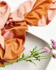 Canyon Hand Embroidered Hand Woven Merino Silk Soft Scarf displayed with flowers in a modern setting.
