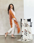 Canyon Hand Embroidered Hand Woven Merino Silk Soft Scarf draped elegantly on a model and chair in a chic setting.