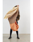 Chestnut Orange Cream Color Block Handwoven Merino Throw held by person showcasing its unique handmade craftsmanship.