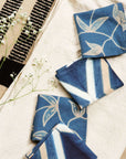 Tisa Indigo Hand Crafted Shibori Print Cotton Table Napkin set of 4 displayed with flowers on a light cloth background.