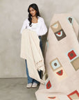 A model holding the Sea Shell White Textured Checks Handloom Throw, showcasing its elegant texture and design.