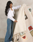 Sea Shell White Textured Checks Handloom Throw being showcased by a model, highlighting its unique texture and design.