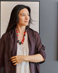 Mihika Red Silk Beaded Necklace Modern Artisanal worn by a model with a purple shawl, showcasing its artistic design.