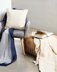 Sea Shell White Textured Checks Handloom Throw draped over a chair, showcasing its modern design and texture.