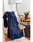 Rosewood Indigo Hand Knotted Stripes Handloom Merino Throw draped over a chair in a cozy living space.