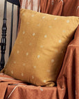 Nira Ochre Hand Spun Organic Cotton Handloom Pillow beautifully displayed on a chair with rich earthy tones.