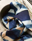 Tisa Indigo Hand Crafted Shibori Print Cotton Table Napkin set of 4 folded in a bowl, showcasing artistic dye pattern.