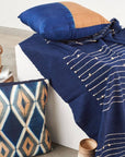 Rosewood Indigo Hand Knotted Stripes Handloom Merino Throw styled on a sofa with coordinating decorative pillows.