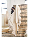 Unah Brown Fully Hand Embroidered Throw Handloom Organic Cotton Throw held by a woman in a bright room.