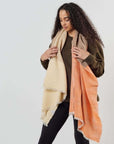 Chestnut Orange Cream Color Block Handwoven Merino Throw draped on a model, showcasing its unique handcrafted appeal.