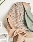 Salvia Green Brown Merino Ombre Handloom Throw draped elegantly over a chair with a modern minimalist design.