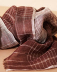 Auro Cinnabar Handwoven Earthy Rust Maroon Linen Scarf displayed elegantly with textured fabric folds.