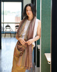 Barque Clay Modern Artisan Striped Soft Merino Handwoven Scarf elegantly styled on a model in a bright, modern setting.
