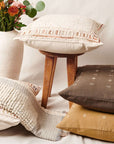 Butterscotch White Handloom Textured Plush Merino Throw displayed with decorative pillows and a vase of flowers.