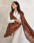 Coco Brown Hand Woven Linen Silk Blend Scarf elegantly styled with a white outfit, showcasing its translucent appeal.