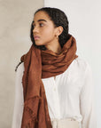 Coco Brown Hand Woven Linen Silk Blend Scarf elegantly styled with a white blouse, showcasing its rich earthy tones.