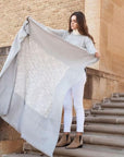 Model showcasing the Flo Gray Textured Handloom Merino Throw, highlighting its luxurious design and craftsmanship.