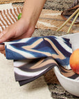 Tisa Indigo Hand Crafted Shibori Print Cotton Table Napkin set of 4 elegantly displayed with a bowl of fruit.