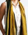 Iris Topaz Yellow Olive Green Cashmere Merino Soft Handwoven Modern Artisanal Scarf worn by a model against a light background.