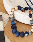 Mihika silk beaded necklace modern artisanal with handcrafted silk beads in shades of blue, cream, and orange.
