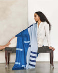 Harbor Blue Silk Merino Hand Woven Hand Embroidered Modern Artisanal Scarf elegantly draped on a model seated on a bench.