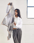 Woman showcasing a Samu Black hand crafted chiffon square scarf, emphasizing its elegant design and versatility in fashion.