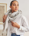 Pebble Light Gray Hand Woven Soft Linen Scarf displayed on a model wearing a white shirt.