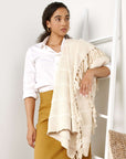 Woman draped in Sea Shell White Textured Checks Handloom Throw, showcasing its elegant design and hand-rolled fringes.