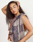 Chiffon square scarf Samu Black styled elegantly by a model with curly hair, showcasing its unique Shibori print design.