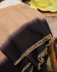 Siro Brown Handwoven Merino Artisan Throw Blanket draped elegantly on a table, showcasing its rich textures and stitching.