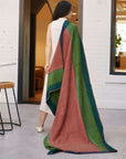 Handwoven Brown Siro Soft Merino Throw Blanket draped over a woman in a bright, modern interior.