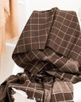 Treacle Checks Pattern Organic Cotton Handloom Throw draped on a chair showcasing its luxurious checked design.