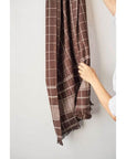Treacle Checks Pattern Organic Cotton Handloom Throw draped and held, showcasing its heritage design and quality craftsmanship.