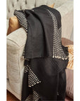 Walnut Black Yak With Hand Knotted Merino Stripes Handloom Throw draped over a couch, showcasing intricate design.
