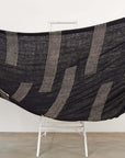 Walnut Black Yak With Hand Knotted Merino Stripes Handloom Throw displayed on a stand with textured stripe design.
