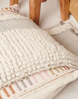 Butterscotch White Handloom Textured Plush Merino Throw draped over decorative pillows on a chair.