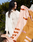 Canyon Orange Hand Embroidered Hand Woven Merino Blend Scarf showcased by a model outdoors in soft natural light.