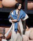 Woman standing with a draped Mahogany Sky Brown Indigo Linen Scarf scarf with silk beaded jewelry styled. 