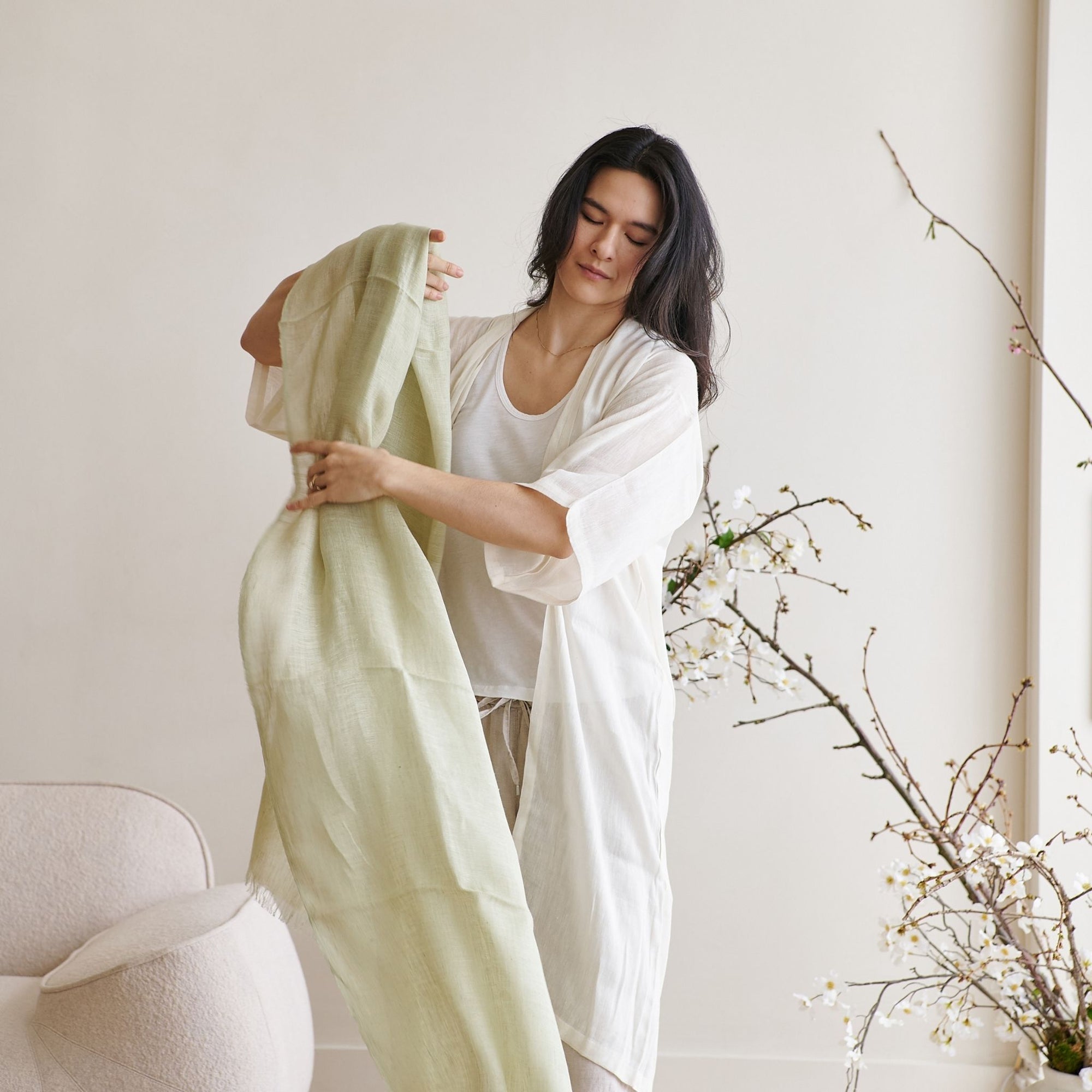 Soya Pastel Lime Green Hand Woven Soft Linen Scarf being worn by a model in a minimalistic room.