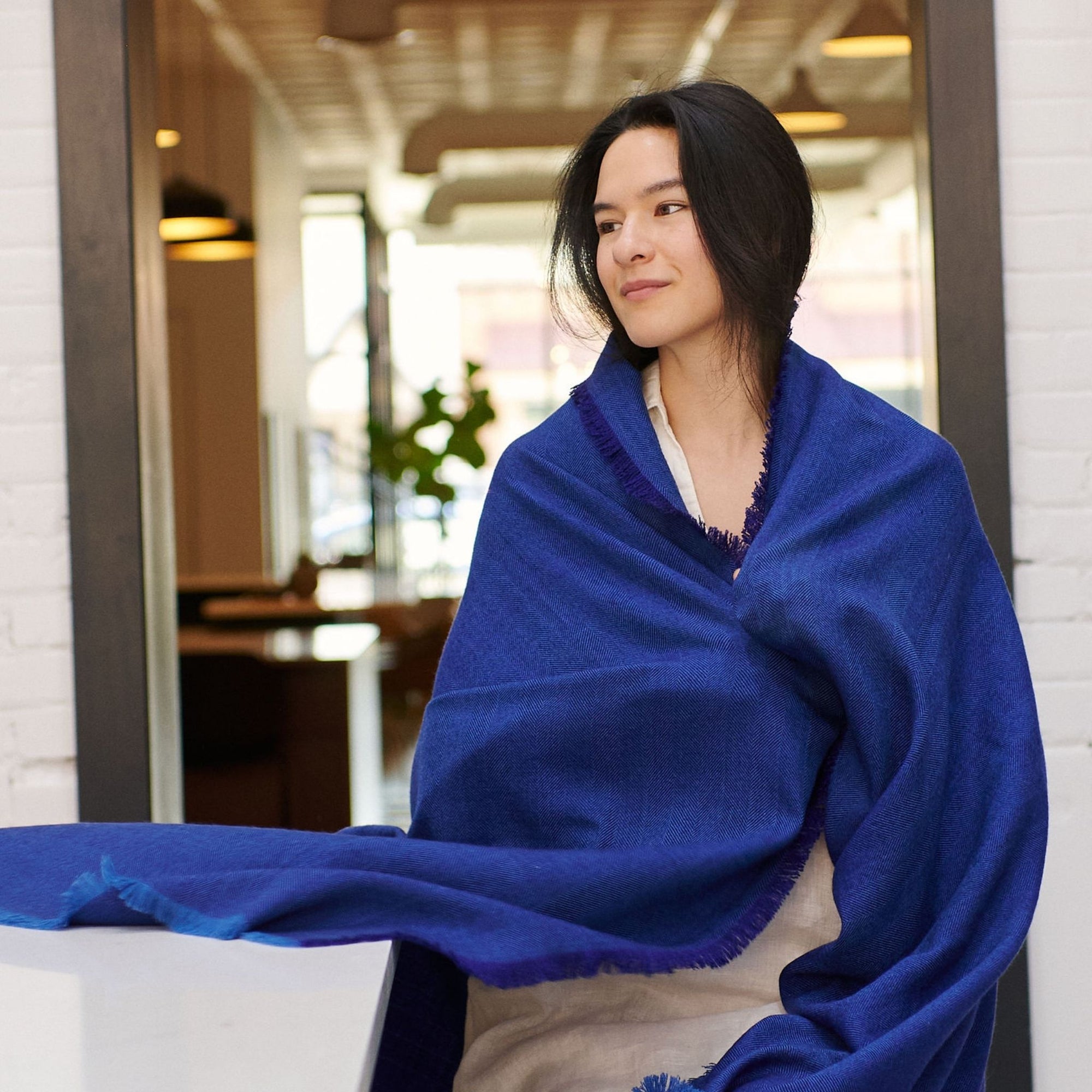 Cobalt Blue Herringbone Plush Soft Merino Handwoven Throw   By Variously  draped on a mode 