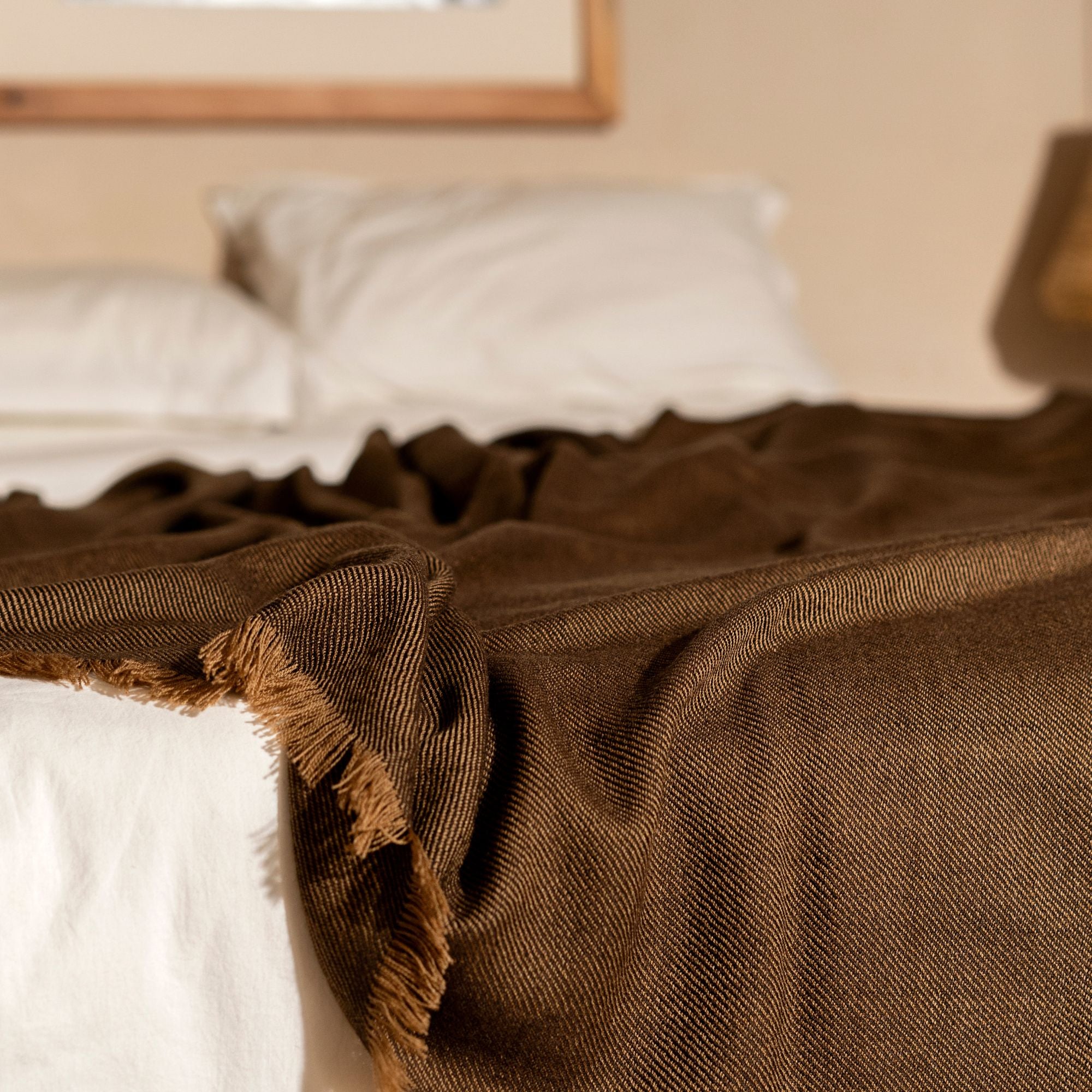 Hay Brown Twill Merino Handwoven Throw draped on a bed, showcasing its soft texture and subtle twill weave.