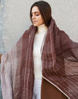 Auro Cinnabar Handwoven Earthy Rust Maroon Linen Scarf draped elegantly over a model wearing a white turtleneck.