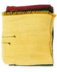 Avocado Green Multi Color Warm Hues Hand Woven Hand Knotted Textured Merino Throw folded and stacked with bold colors.
